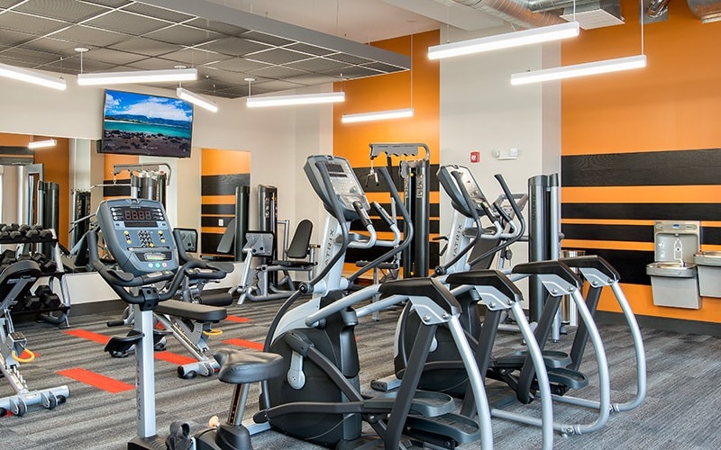 spacious fitness center with equipment and modern colorful walls