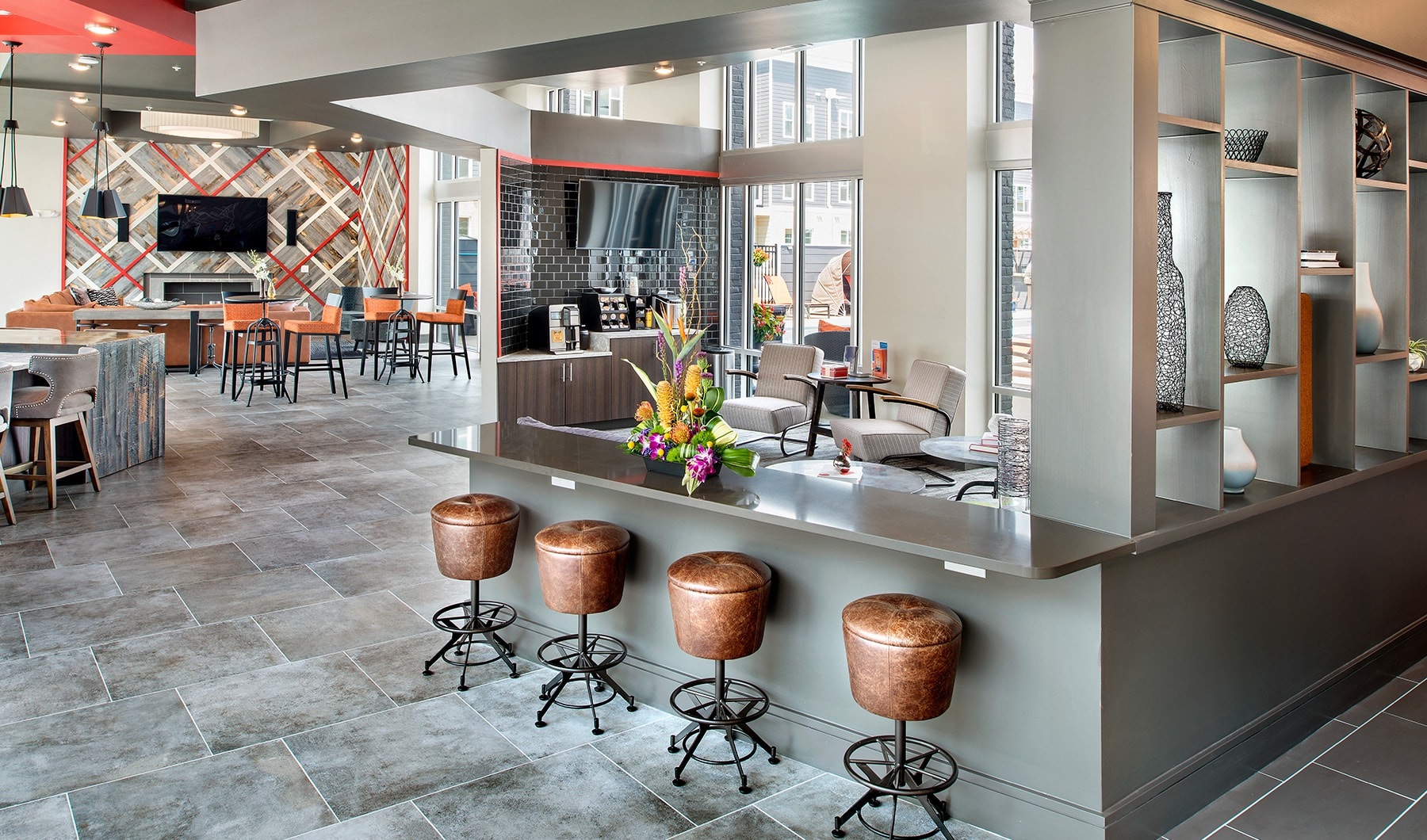 Living Begins Here lounge area with modern bar stools, a coffee bar, ample couches and modern-spacious areas